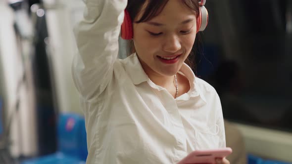 Young Woman Using Mobile Phone on Public Train