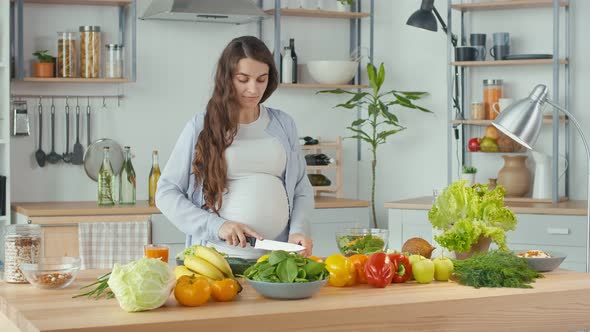 Beautiful Pregnant Woman Happily Preparing a Vegetable Salad The Concept Of Diet