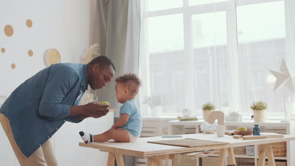 Father and Toddler Eating Apple