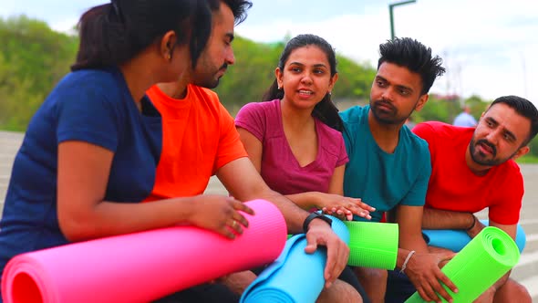 Eastern Ethnic People Exercising Together Outdoor Talking