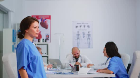 Nurse Looking at Camera Smiling Standing in Medical Conference Office