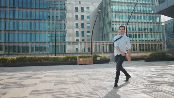 Flexible and cool businessman doing acrobatic tricks outdoor.