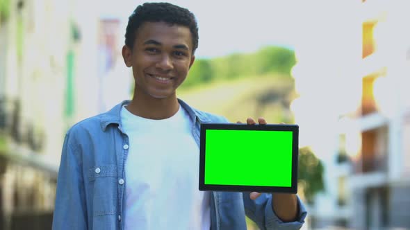Excited Black Boy Pointing Finger at Green Screen Tablet in Hand, Advertising