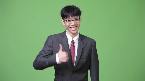 Young Happy Asian Businessman Smiling While Giving Thumbs Up