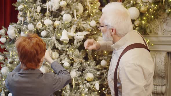 Grandfather and Kid Decorating Christmas Tree and Hugging