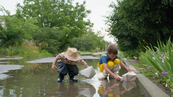 Outdoor Children, Cheerful Kids Male in Rubber Boots Enjoy Spending Time Together on Streets Playing