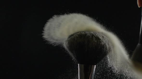 Make Up Brushes with Facial Cosmetics Powder on Black Background in Slow Motion