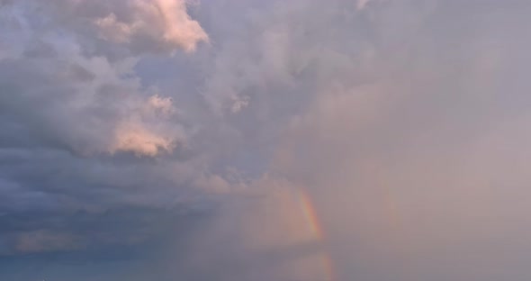 In the Sky of a Severe Thunderstorm a Bright Rainbow is Seen Against a Landscape of Clouds