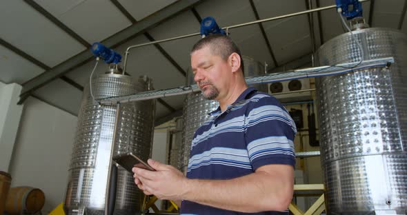 Male worker using digital tablet in distillery 4k