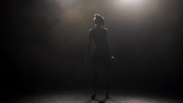 Silhouette of Young Dancer in Darkness of Studio