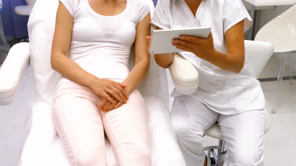 Doctor and female patient discussing on digital tablet