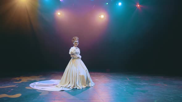 a theater actress with flowers in her hands in a bride's dress on stage. opera. performance.