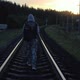 A Lonely Hooded Traveler Walking the Railway at Sunset - VideoHive Item for Sale