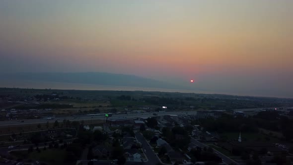 Beautiful aerial red sunset in a smoggy sky from summer wildfires. View of the sunset with mountains