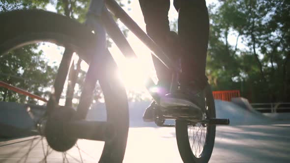 Close Up Shot of Young Man Riding BMX Bike in Extreme Park and Doing Tricks