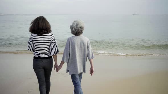 Happy Daughter and Mother Entering Into Sea Water