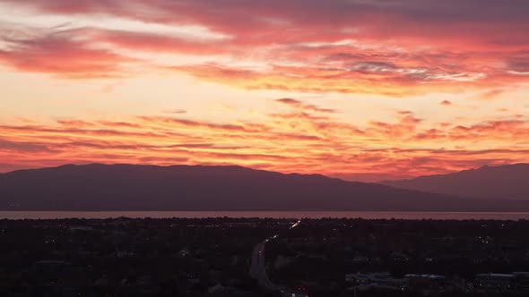 Time lapse of colorful sunset with traffic driving on road