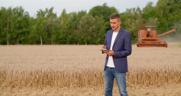 Agriculture - Farmer Using Digital Tablet During Harvesting