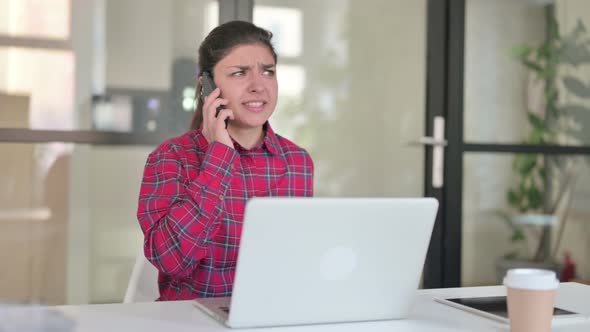 Indian Woman Feeling Angry on Smartphone While Using Laptop