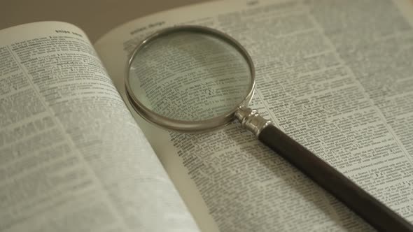 Magnifying glass on large opened book