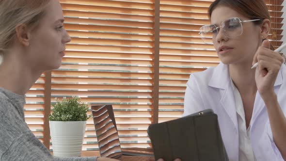 Young woman doctor talking and discussion with patient about disease and illness for diagnostic.