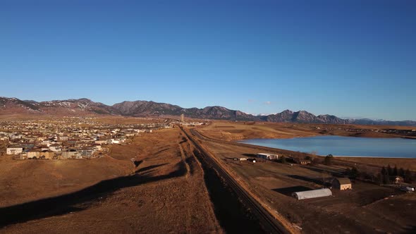 Railway leading from Denver to the foothills of Boulder Colorado during golden hour, aerial