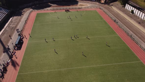 drone top view shot of a hockey game on a beautiful green grass field