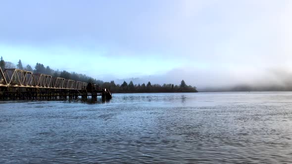 Large steel pivot railroad bridge spanning the Umpqua River bay near Reedsport Oregon