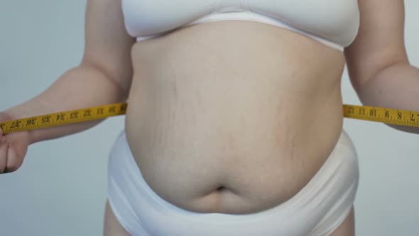 Overweight Female Taking Stomach Measurements, Health, Dieting and Motivation