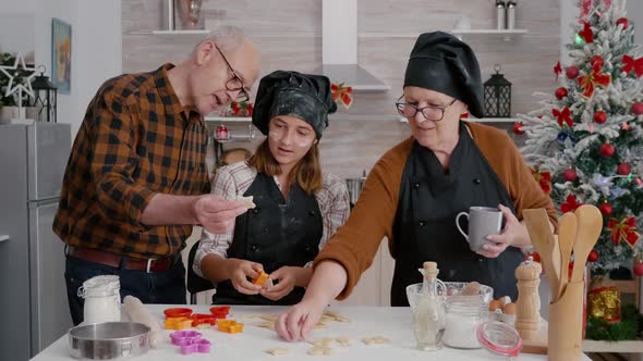 Grandparents Teaching Granddaughter How Prepare Gingerbread Dessert Shape