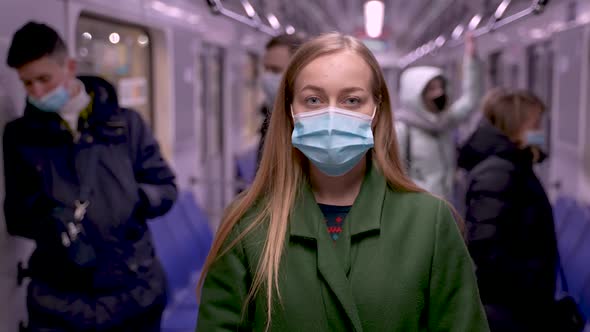 Blonde Young Woman in Medical Mask in Metro Train