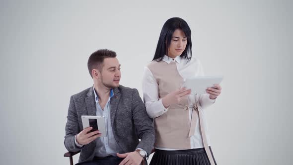 Man and woman are holding gadgets