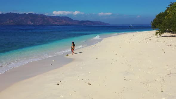 Lonely girl wearing snorkel set, walking around exotic beach of tropical island seeking for ideal pl