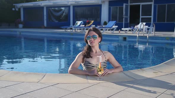 Hot Single Woman in Bikini Enjoying Cocktail in Swimming Pool