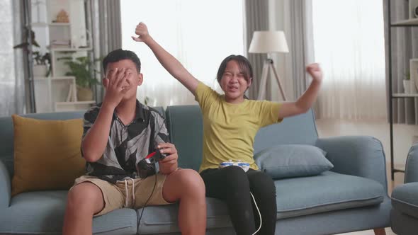 Children With Joystick Game Play Video Game On Tv, Girl Celebrating Victory And Boy Disappointed