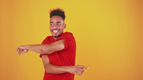 Studio Shot of Excited African American Guy Dancing Fastly Orange Studio Background