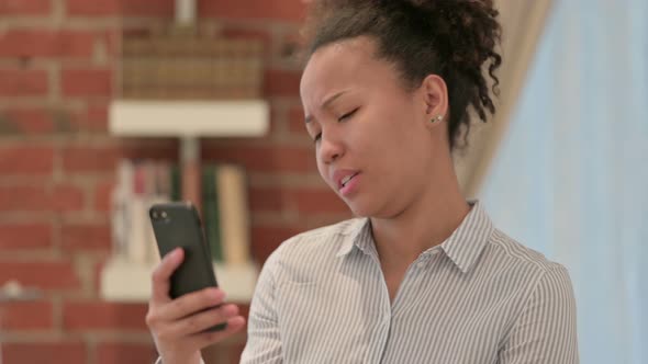 Portrait of African American Woman Reacting to Loss on Smartphone