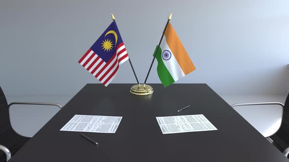 Flags of Malaysia and India and Papers on the Table