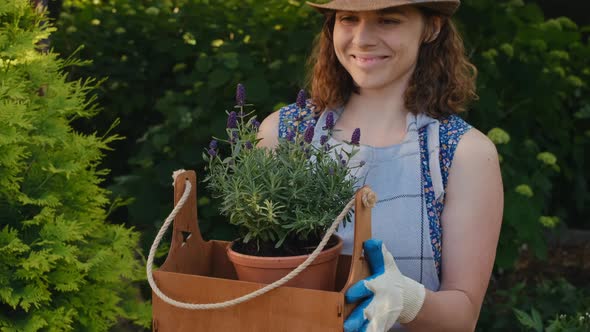 Young Woman Sniffs Potted Lavender Plant Outdoors