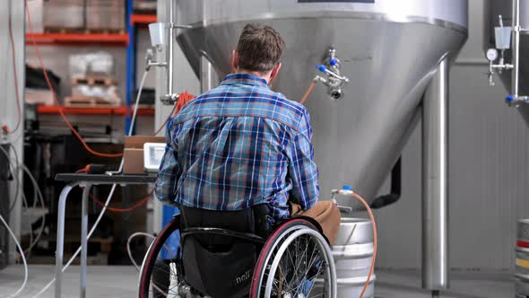 Man in Wheel Chair Working in Brewery Factory