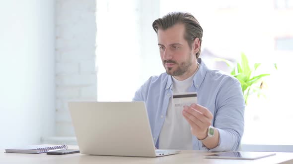 Happy Young Man Shopping Online on Laptop