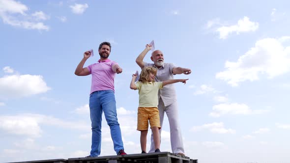 Happy Family of Boy Child with Dad and Grandad Point Fingers Holding Paper Planes Skyhigh Pointing