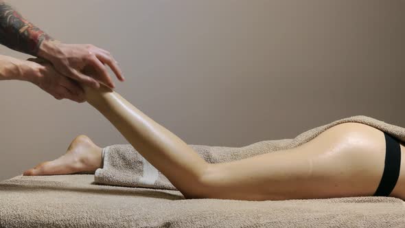 Young woman having feet massage in beauty salon, close up view.