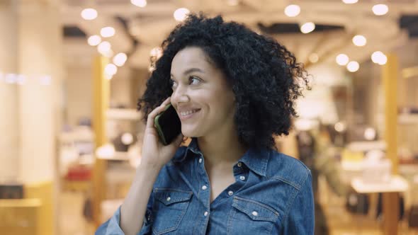 Smiling African American Woman Talking on the Phone in the Mall