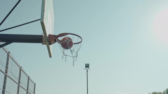 Basketball Ball Gets Into the Ring Against a Blue Sky Background