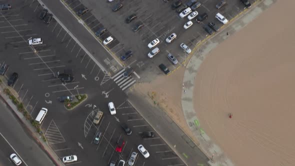 AERIAL: Looking Up Over Parking Lot Revealing Santa Monica Pier, Los Angeles From Above at Beautiful