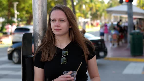 Young Pretty Woman Has a Cold Drink in the Sun of Miami Beach