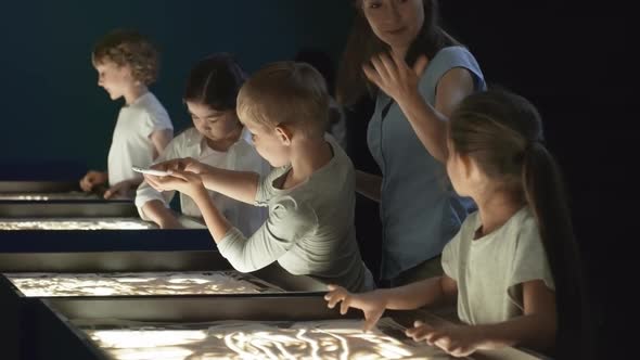 Children Appreciating Sand Drawing Made by Classmate