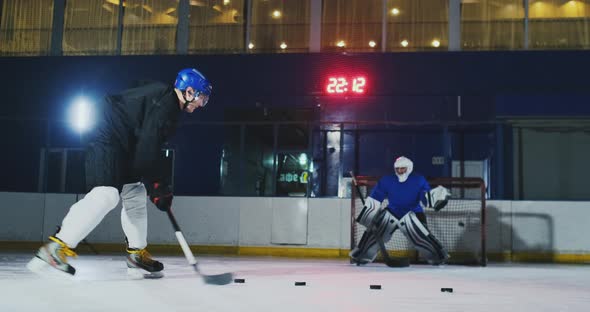 Professional Hockey Player and Goalkeeper Train Punching Puck on Goal. Goalkeeper and Player in