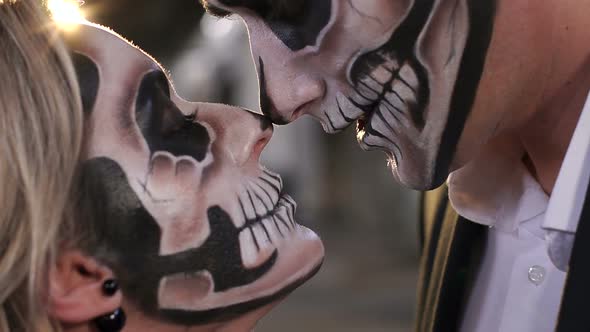 Halloween Loving Couple with Skull Makeup Looking at Each Other.